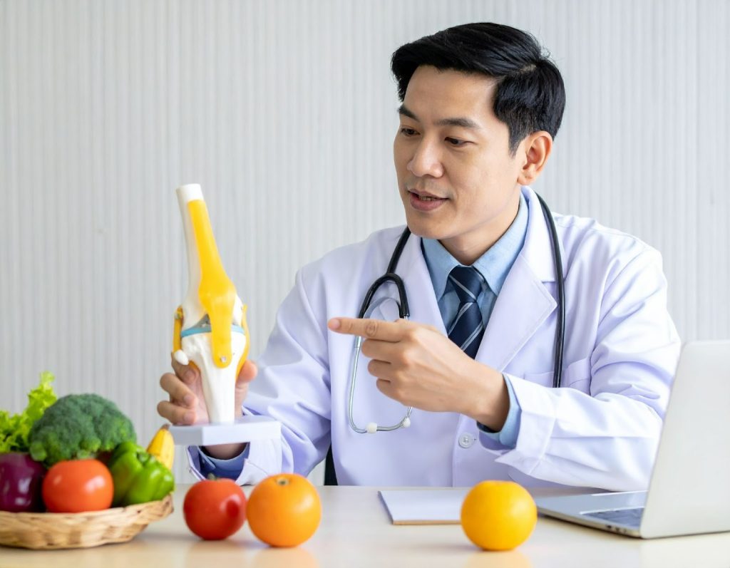 醫師指著關節模型向中年患者解說保健食品功效