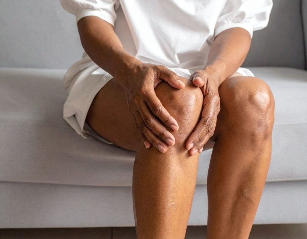 中年女性坐在沙發上按著膝蓋