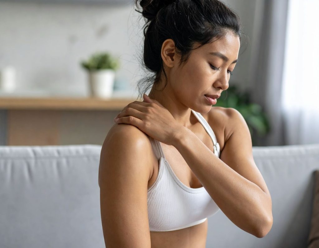 動後坐在沙發上輕揉肩膀，表情不適